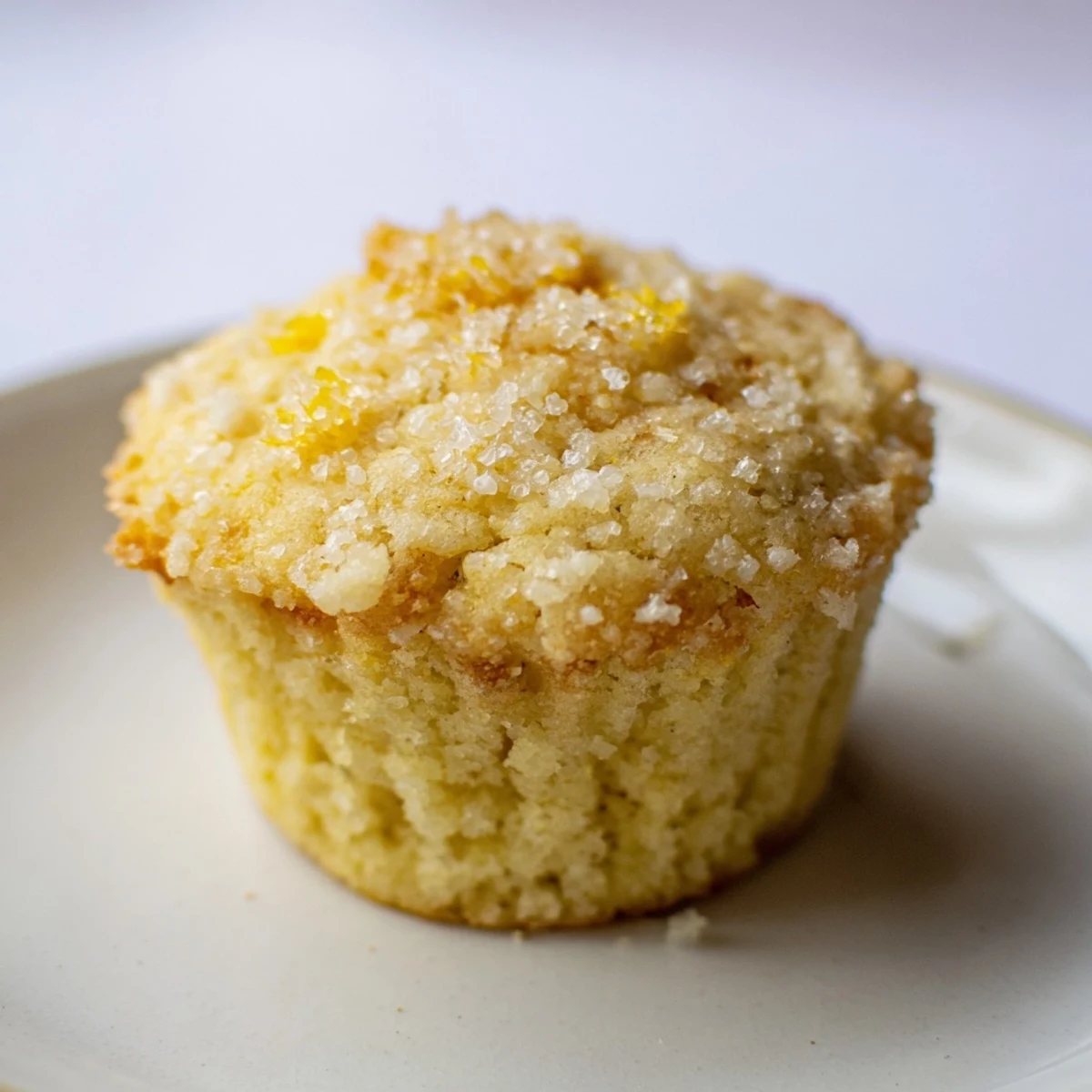 Simple sweet lemon zest muffins, golden brown and fluffy, perfect with a cup of hot coffee at breakfast.