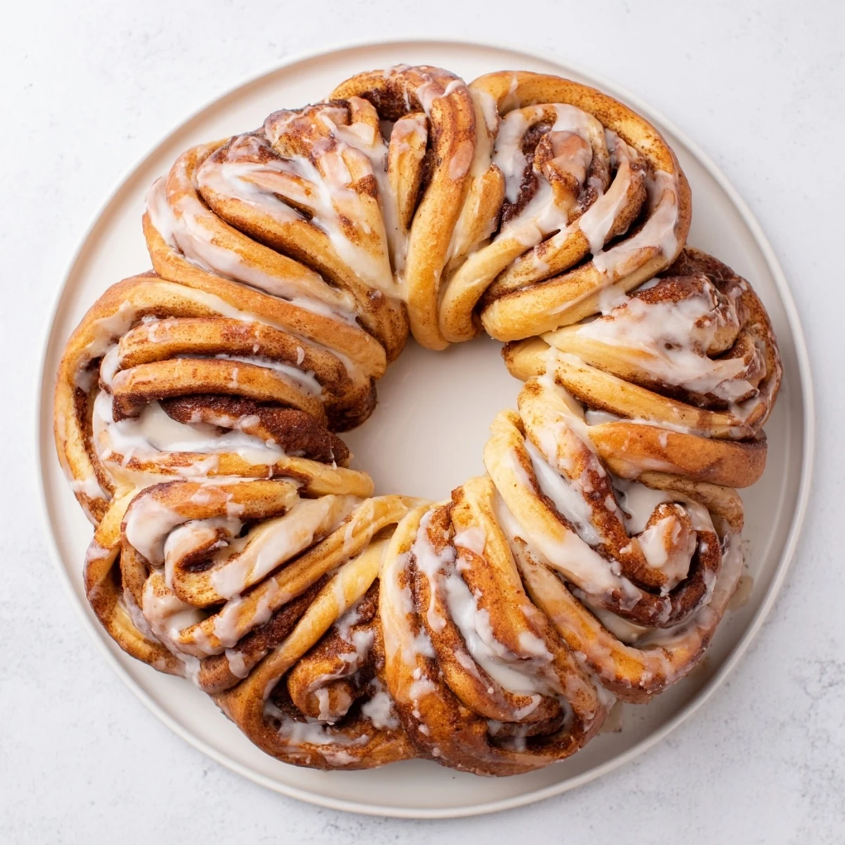 A freshly baked cinnamon roll pull-apart wreath, beautifully shaped with a sweet vanilla glaze.