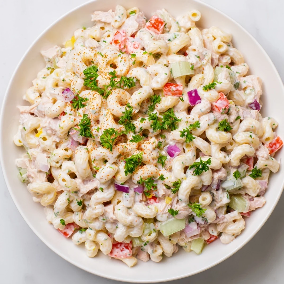 Chilled Chicken Macaroni Holiday Salad, a Southern delight, includes fresh parsley and paprika for garnishing.