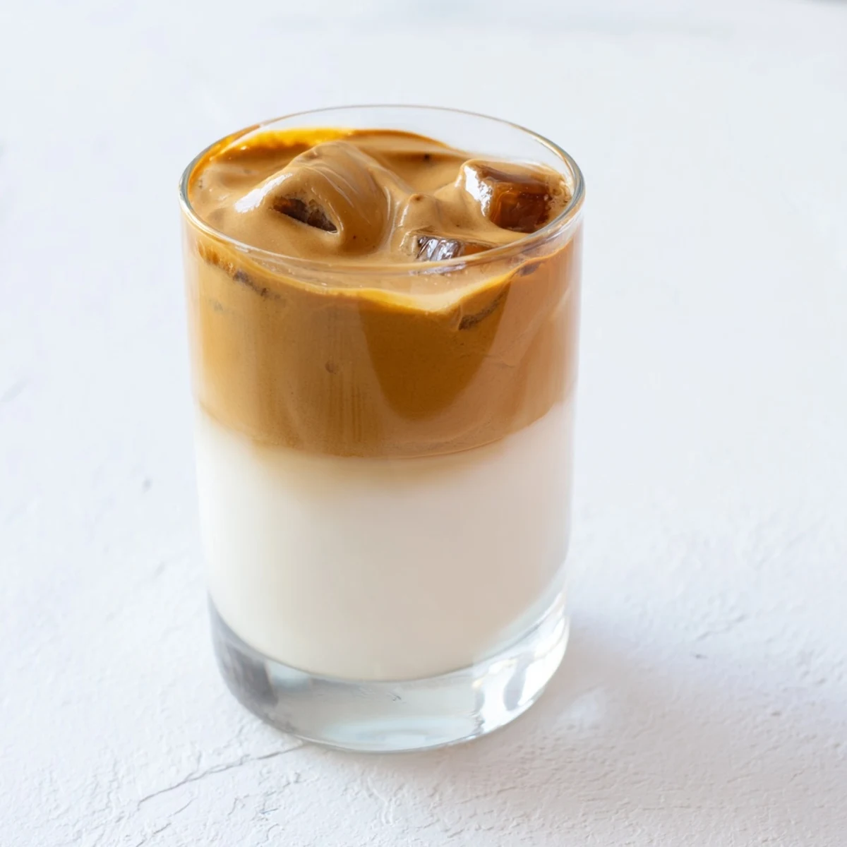 Fluffy brown sugar dalgona latte, a whipped coffee cloud atop cold milk, ready to sip.