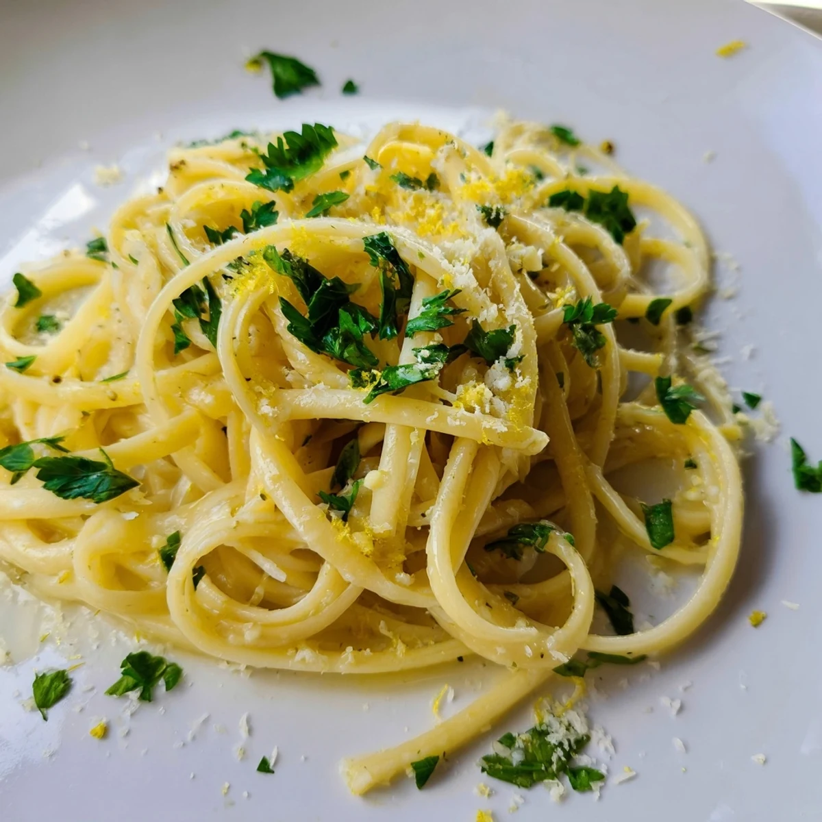 Golden, glossy garlic butter linguine, sprinkled with fresh parsley and ready to serve.