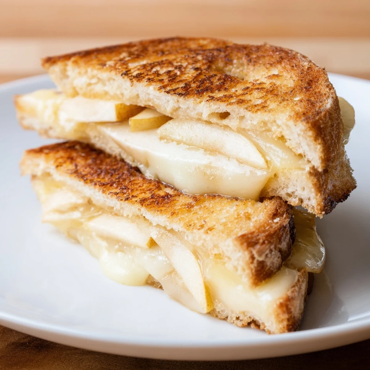 Golden, melty Brie and apple grilled cheese—a gourmet sandwich, warm and comforting.