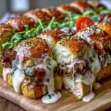 Warm turkey and bacon sliders on brioche buns, topped with creamy Gruyère Mornay sauce and fresh parsley.