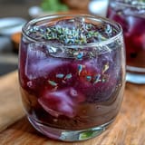 Vibrant purple lemonade refresher featuring fresh lemon slices, lavender sprigs, and a stunning lavender-infused hue for a cooling drink.
