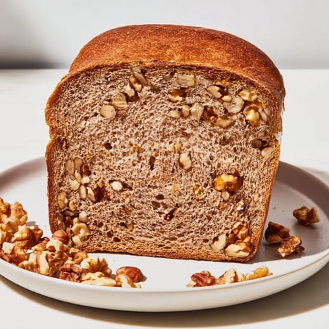 Freshly baked Nutty Whole Wheat Loaf Bread with visible nuts, ready to make delicious sandwiches.