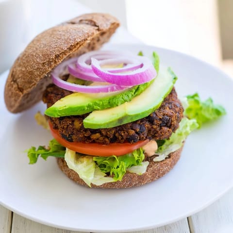 Golden-brown Zesty Weeknight Black Bean Burgers ready to eat, served with vibrant fresh garnishes.
