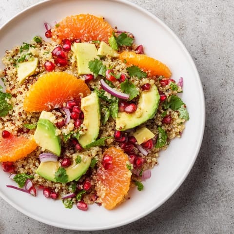 A close-up of a Fresh Citrus & Avocado Quinoa Bowl, showcasing vibrant colors and fresh herbs.
