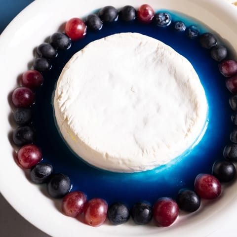 A vibrant photo of a delicious, artful Floating Island recipe, ready for serving with grapes.