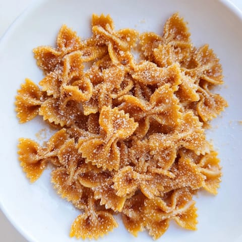 Bowtie pasta transformed into delicious Air Fryer Pasta Christmas Crack, coated with cinnamon sugar, ready to eat.