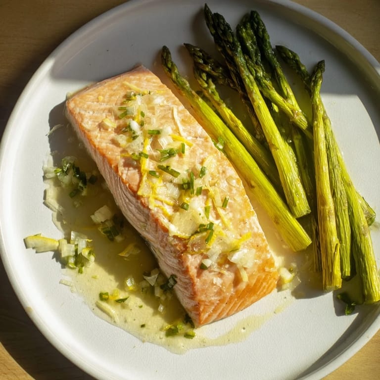 A close-up of flaky Skillet Lemon-Butter Salmon, glistening with a vibrant lemon-butter sauce and fresh herbs.