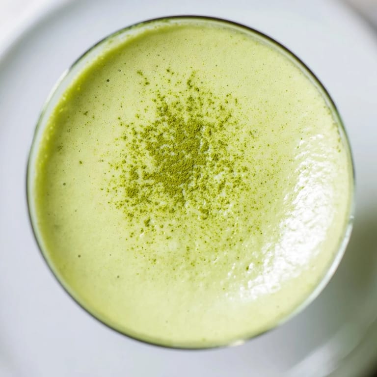 A creamy Matcha Martini cocktail in a martini glass, garnished with matcha powder and a rich, velvety texture perfect for sipping.