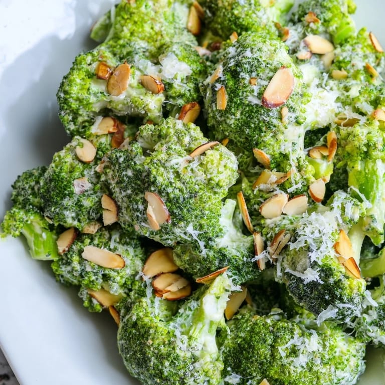 Fresh Garlic Parmesan Broccoli Salad with juicy cherry tomatoes, crunchy almonds, and a smooth, tangy dressing, ready to serve.