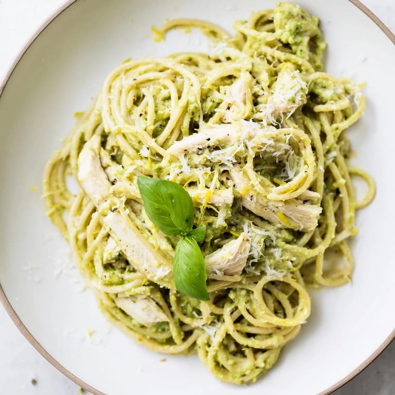 A plate of Creamy Avocado Chicken Pasta topped with grated Parmesan and red pepper flakes, ready for a quick, nutritious weeknight dinner.